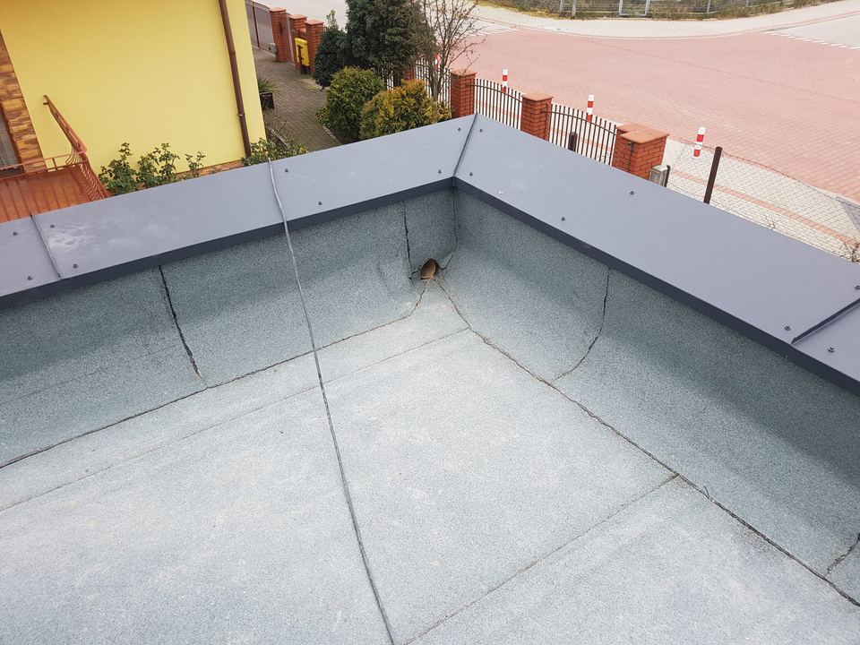 Angle de toit-terrasse : relevé d’étanchéité le long de l’acrotère, sous une couvertine métallique