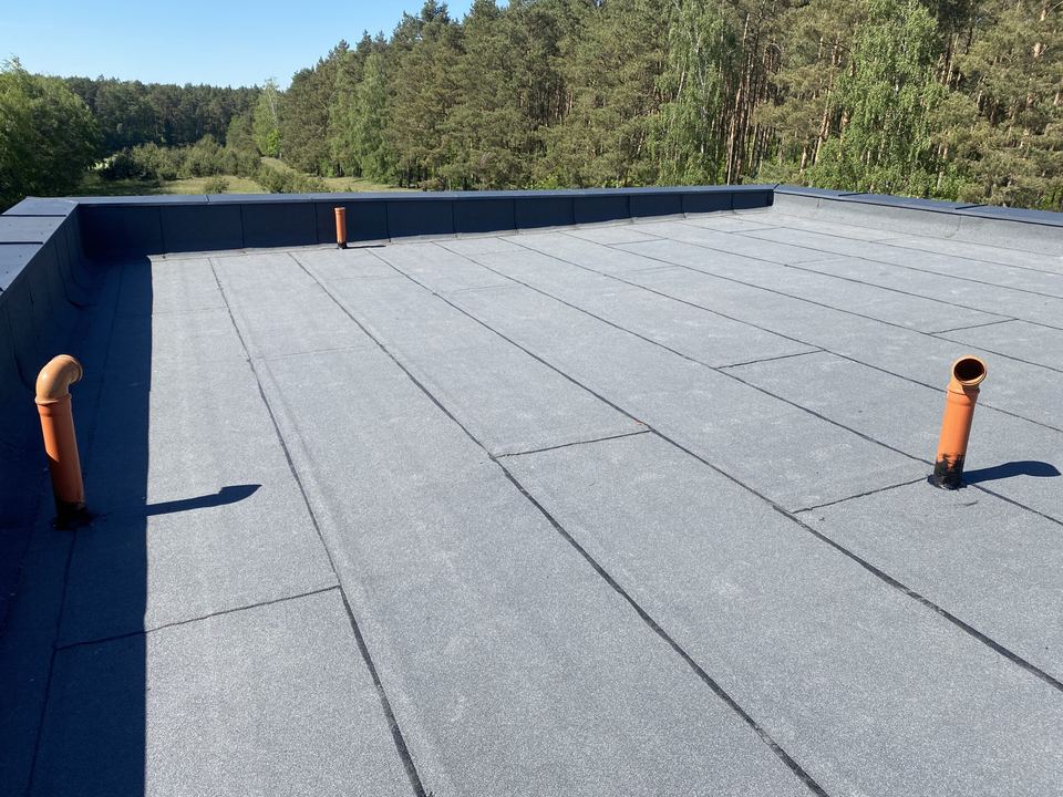 Toit-terrasse revêtu d’une étanchéité bitumineuse, avec sorties de ventilation et acrotères