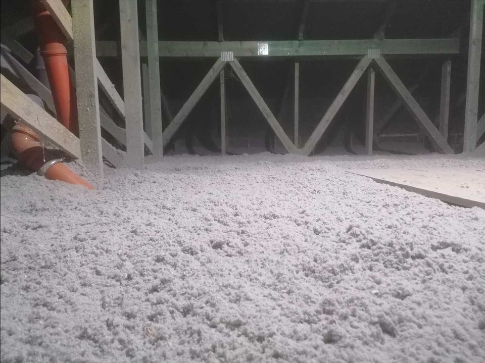 Plancher de combles perdus recouvert d’isolant en vrac, sous une charpente en fermettes