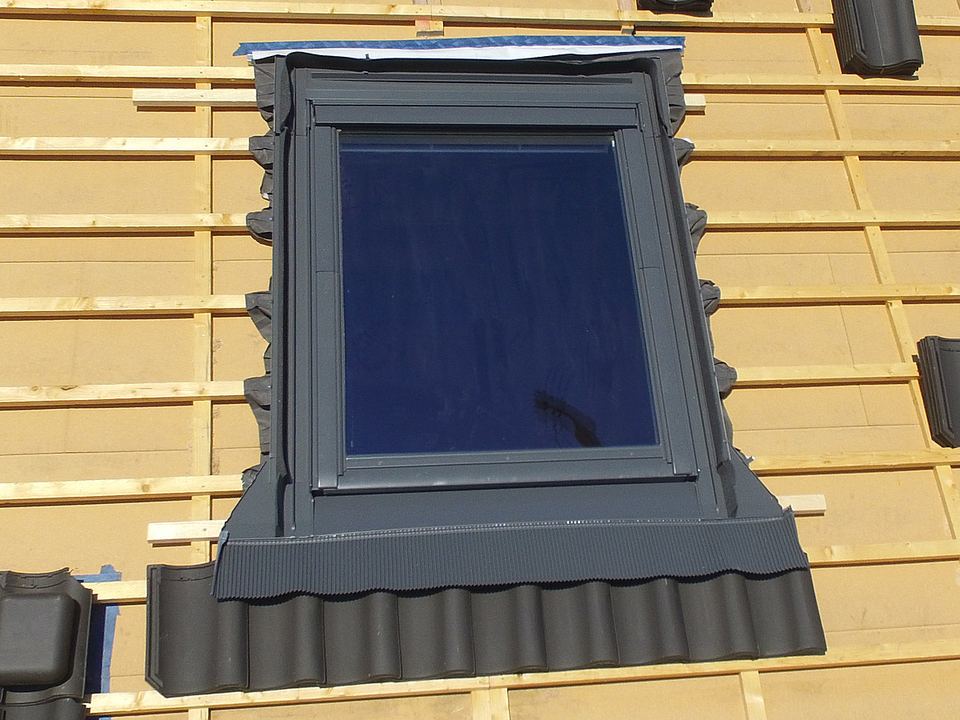 Fenêtre de toit en cours de pose, raccord d’étanchéité visible avant la remise des tuiles